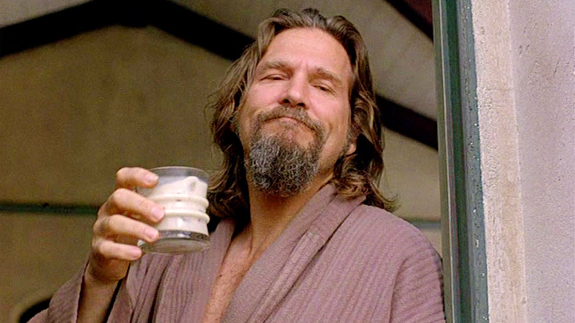 A man holds up a beverage in a glass, from the film The Big Lebowski