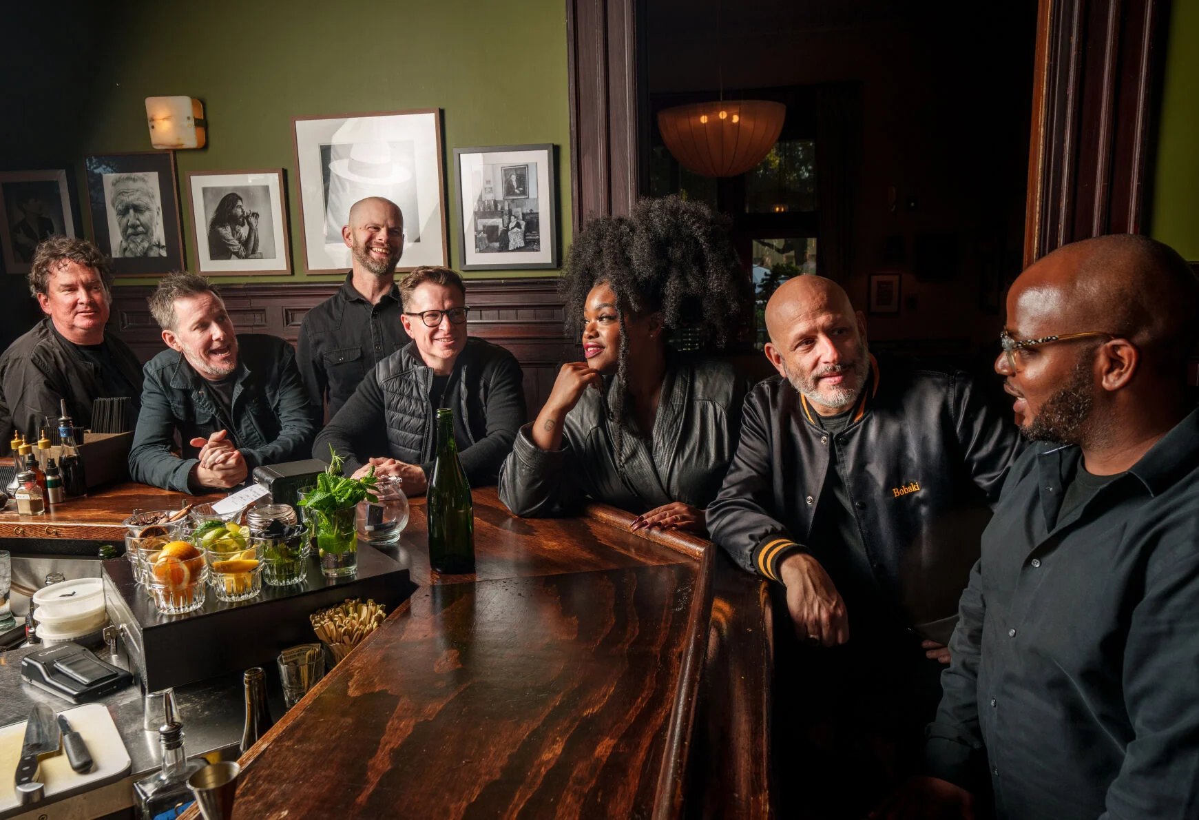 Band members of the musical group Galactic seated around a bar at a restaurant