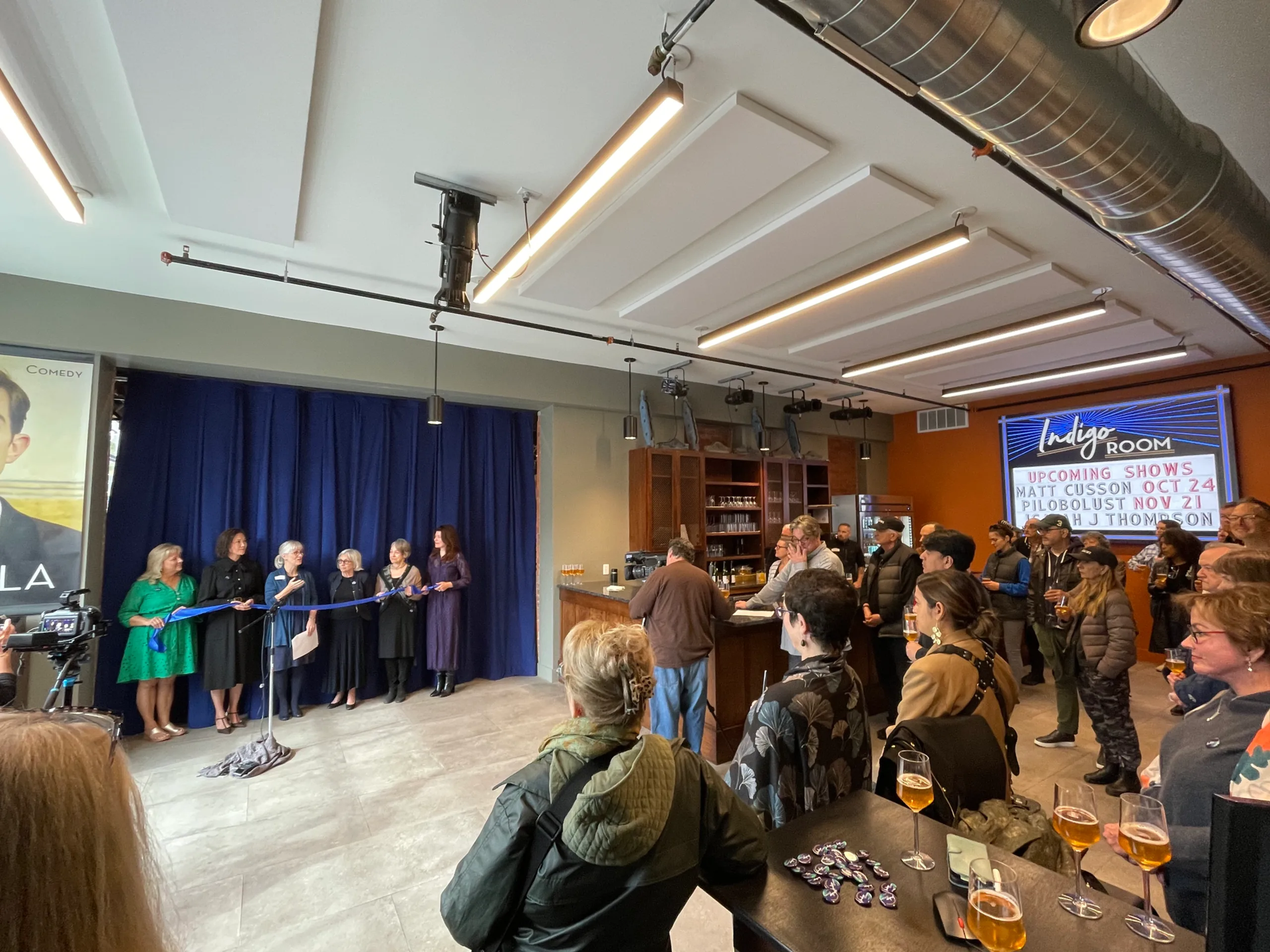 People in a room observing a ribbon cutting ceremony