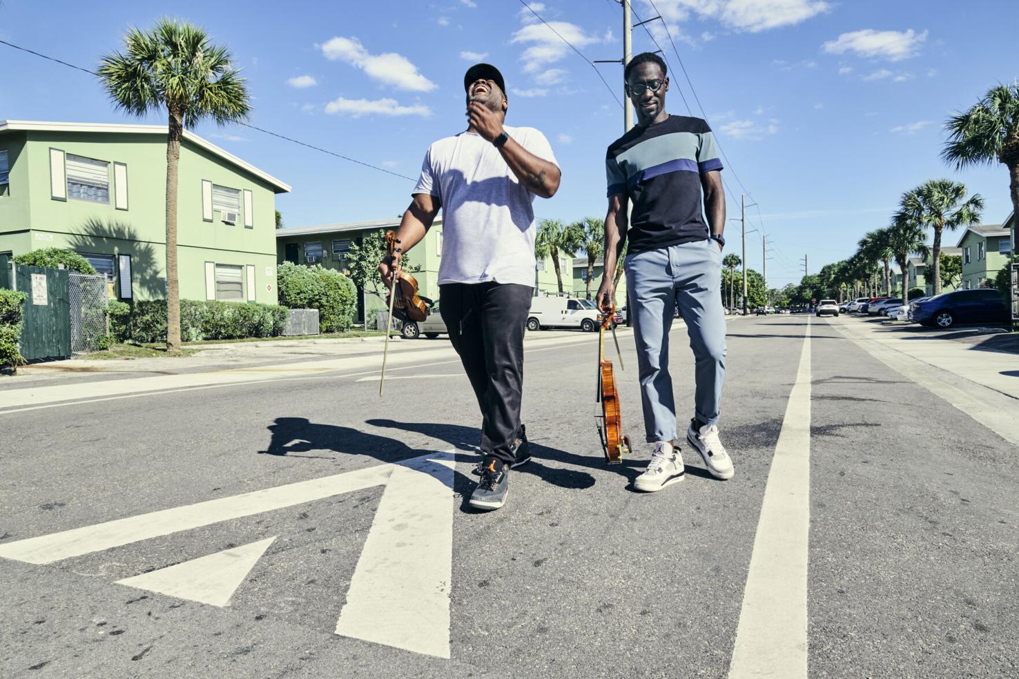 The musical duo Black Violin standing outside on a street
