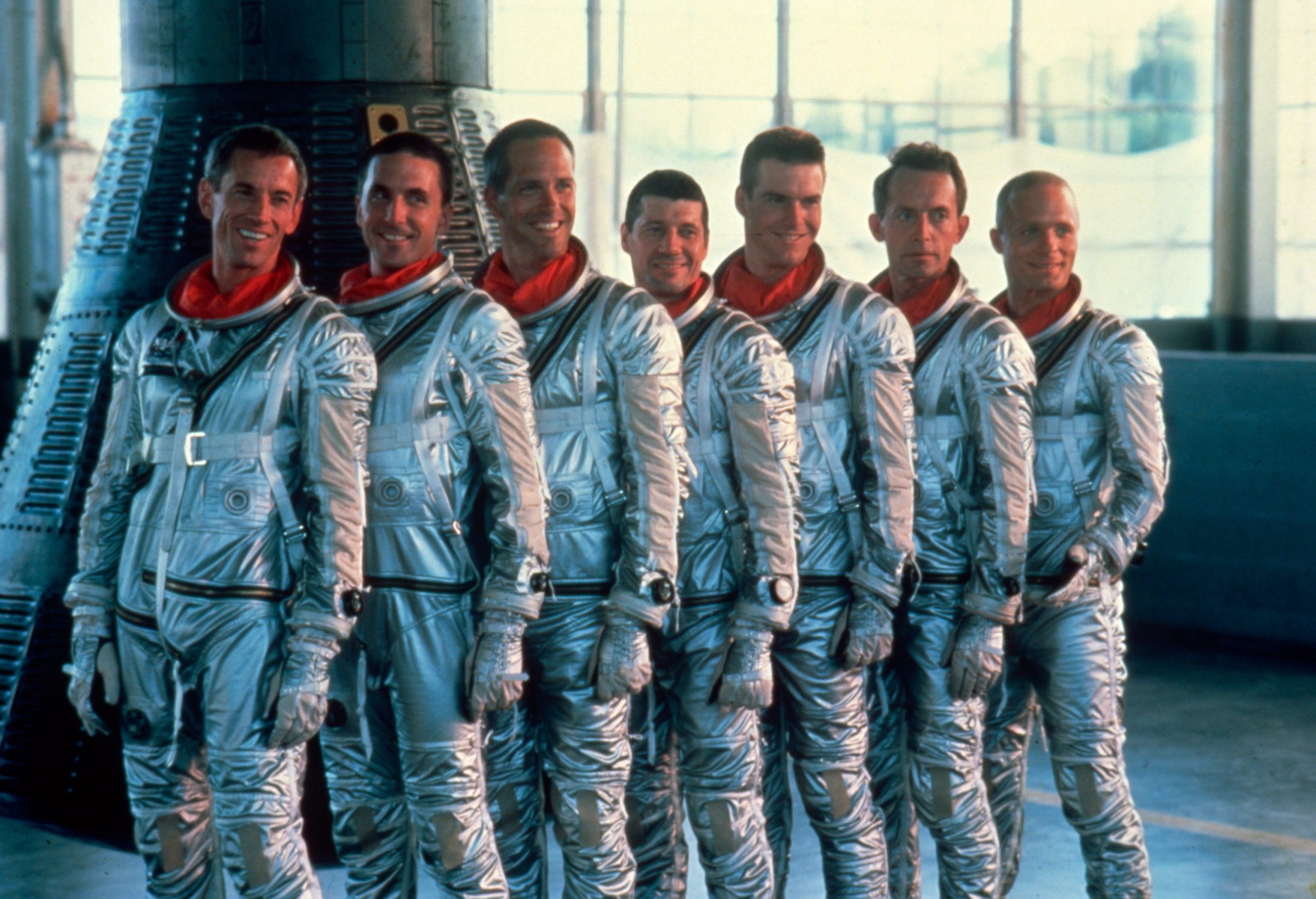 A line of astronauts, in full gear, standing in front of a space shuttle.