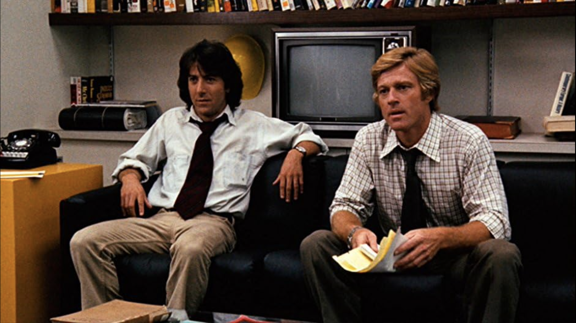 Two men sitting on a couch in an office