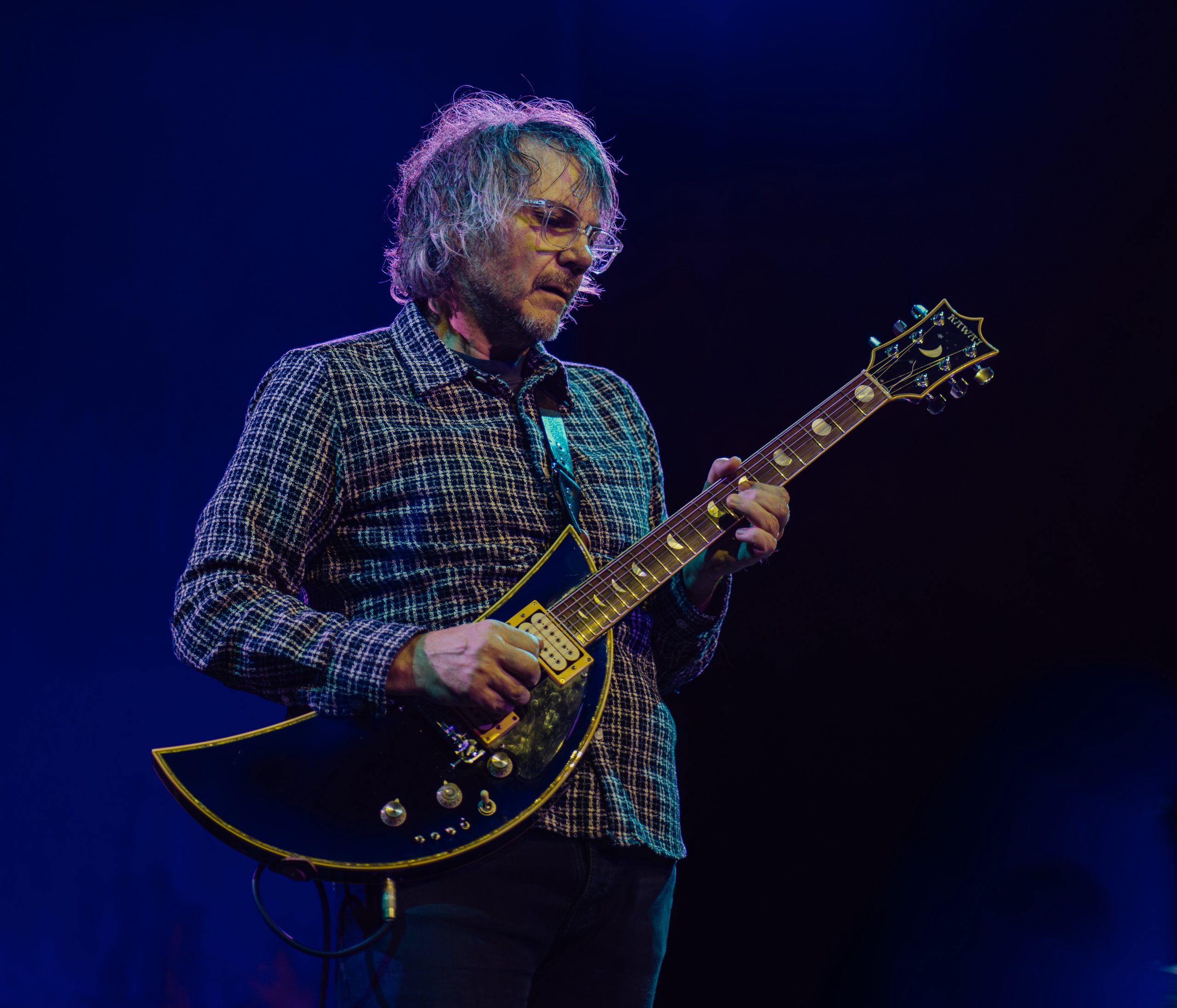A man with a crescent-shaped guitar
